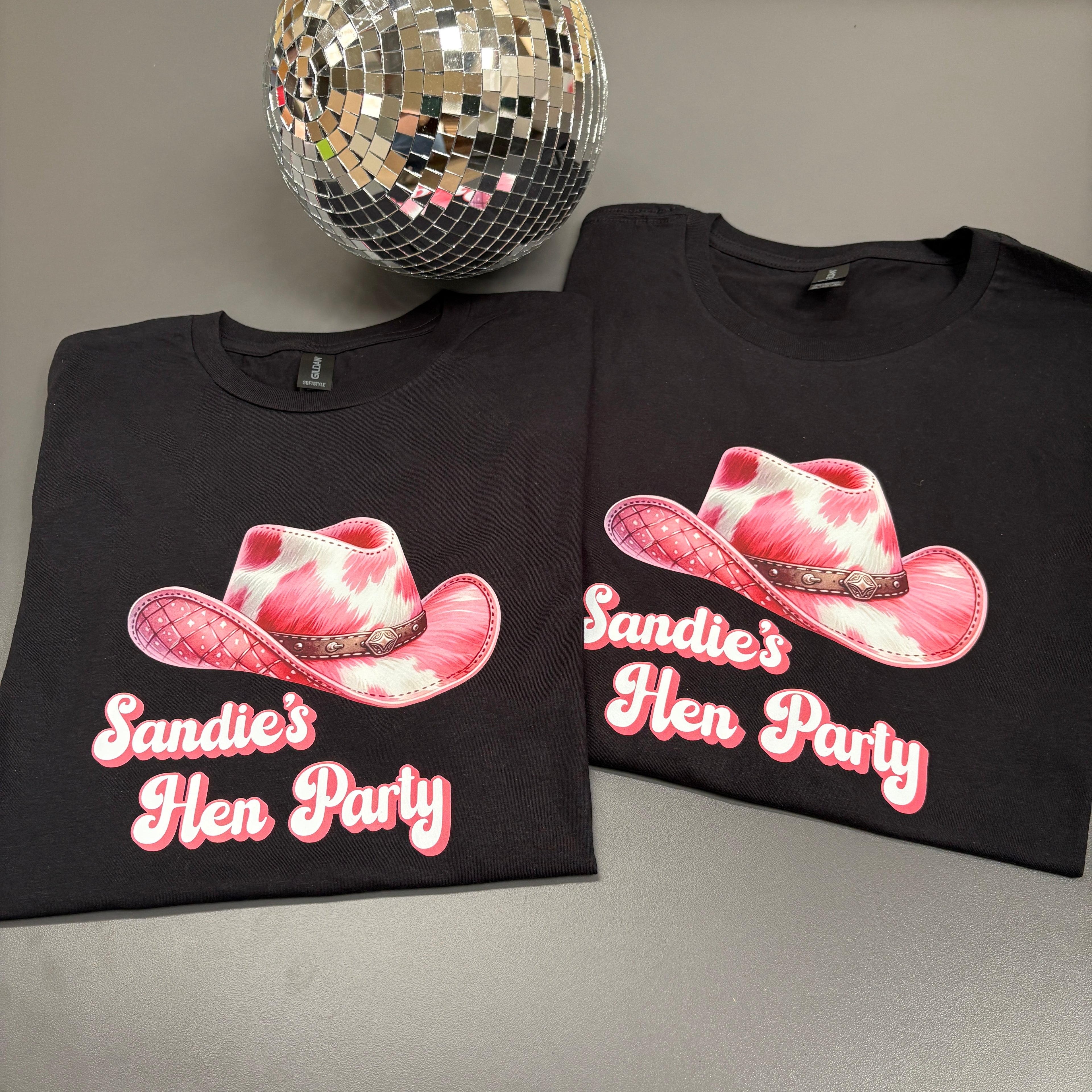 Hen party t-shirts in black with a mirror ball on a grey background. 