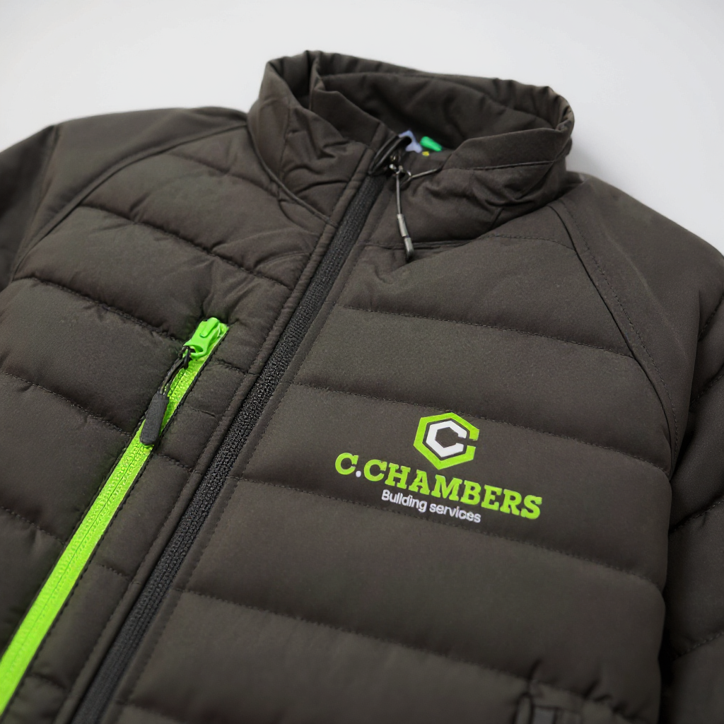 Black puffer jacket with green zipper and branding on a light gray background